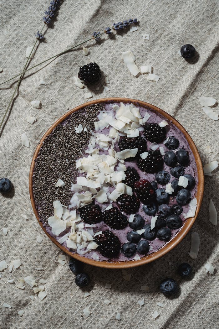 Delicious smoothie bowl topped with blueberries, blackberries, chia seeds, and coconut flakes.